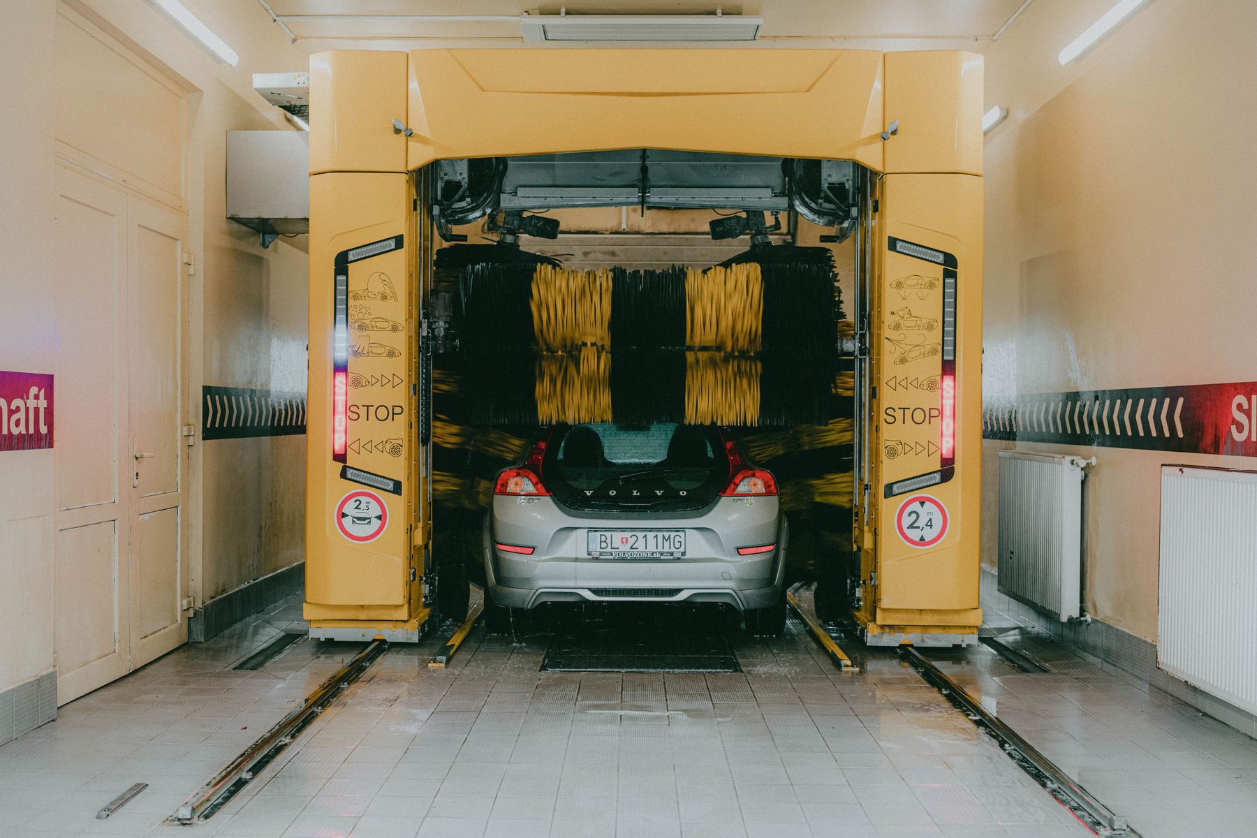 A car pulled into an automatic tunnel wash between the spinning brushes